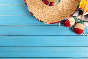 Mexican background serape striped blanket with sombrero maracas on old blue wood floor Mexico cinco de mayo festival vacation photo