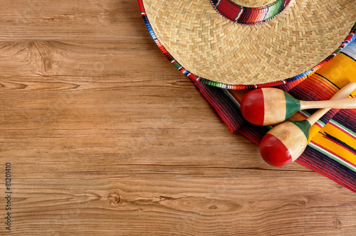 Mexican background serape striped blanket with sombrero maracas on wood wooden floor Mexico cinco de mayo festival vacation photo