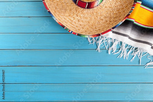 Mexican background serape striped blanket with sombrero maracas on old blue wood floor Mexico cinco de mayo festival vacation photo