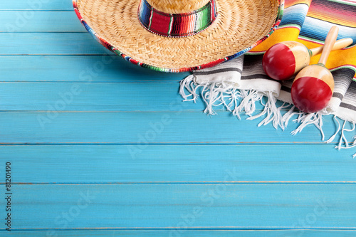 Mexican background serape striped blanket with sombrero maracas on old blue wood floor Mexico cinco de mayo festival vacation photo