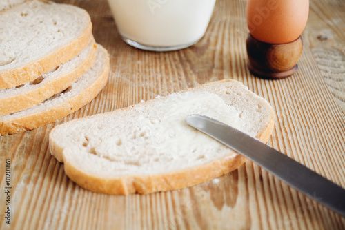 sliced bread, milk and egg on wooden surface