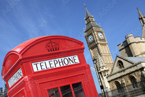 London red telephone box booth with westminster houses of parliament building and Big Ben clock tower in the background photo