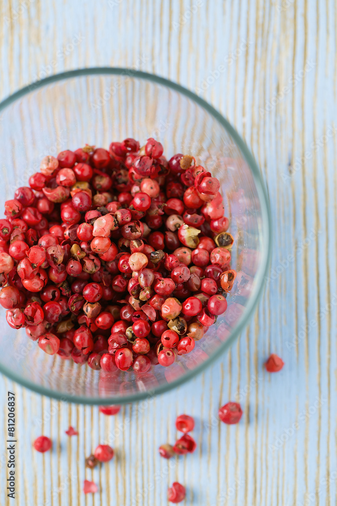 red peppercorns on wooden table red peppercorns on wooden table