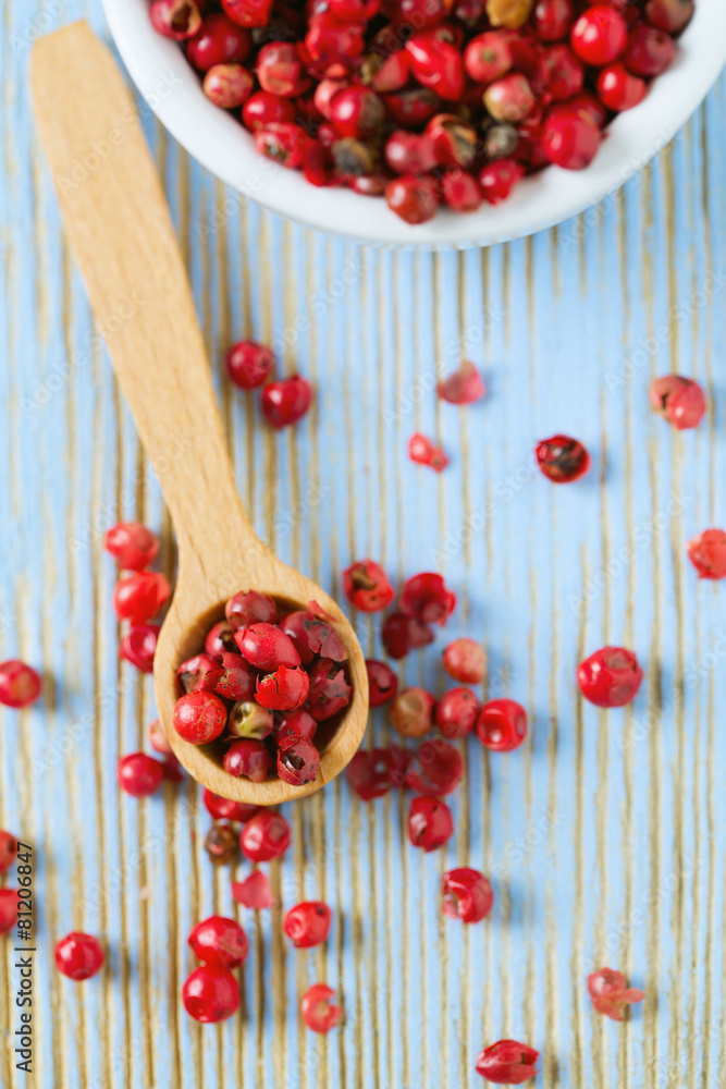 red peppercorns on wooden table red peppercorns on wooden table