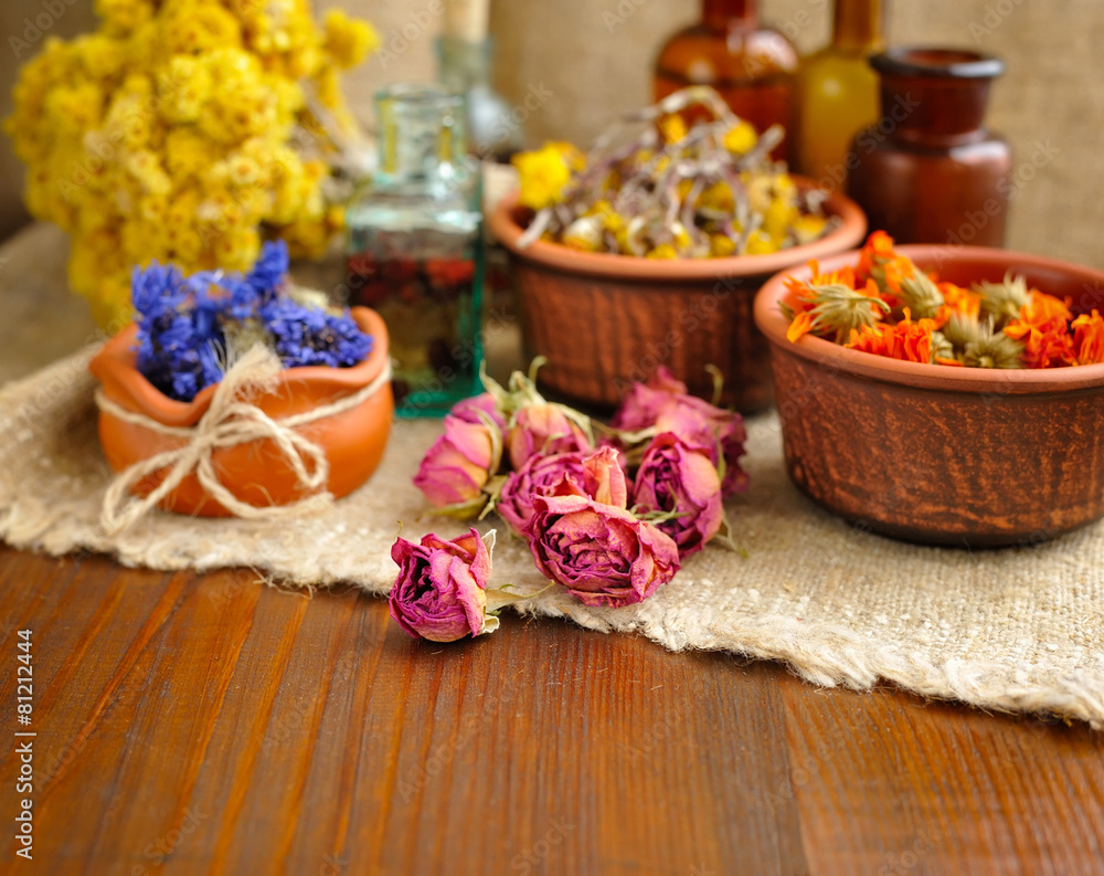 Healing herbs and tinctures in bottles on sackcloth