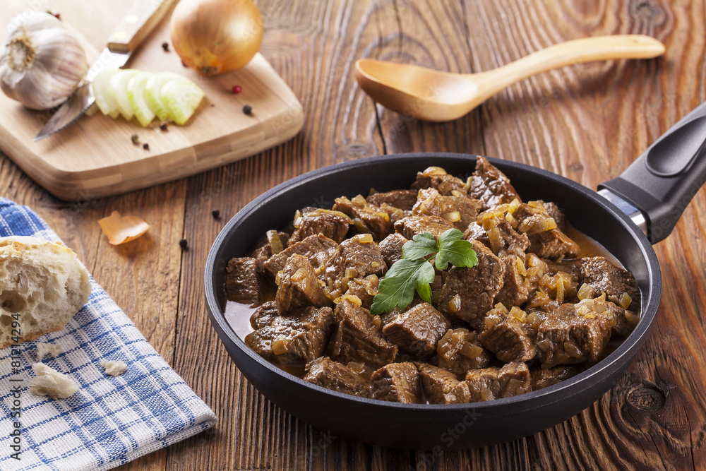 Beef stew - wooden background Beef stew - wooden background