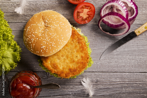 Home made chicken burger with lettuce, tomato and onion photo