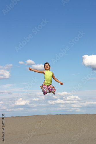 happy little girl jumping on beach