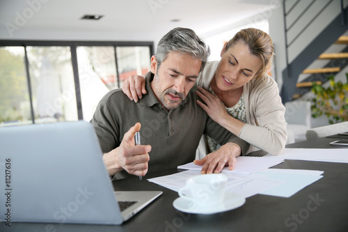 Couple calculating financial savings on internet