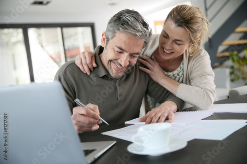 Couple calculating financial savings on internet © goodluz