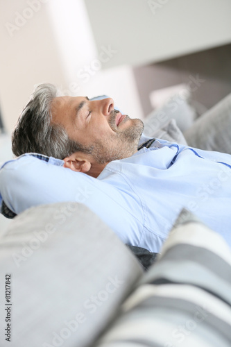 Принти на полотні Middle-aged man having a restful moment relaxing in sofa