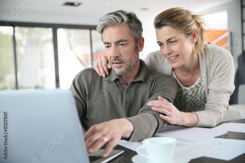 Couple calculating financial savings on internet