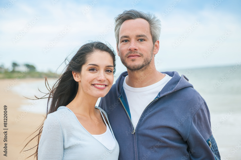 A beautiful couple is posing holding eachother at the beach A beautiful couple is posing holding eachother at the beach