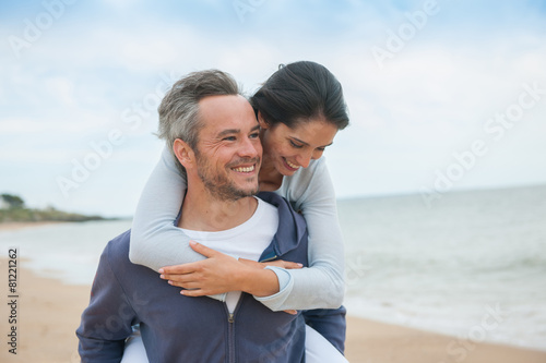 A beautiful couple is posing holding eachother at the beach © jackfrog
