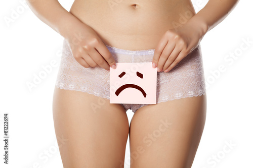 woman holding a paper with a gesture of grief over her vagina