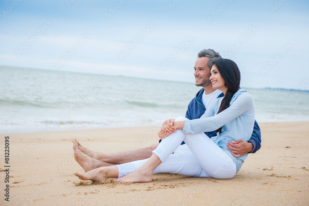 A beautiful couple is holding eachother at the beach