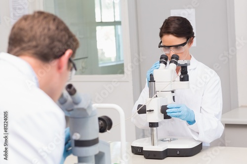 Scientists looking attentively in microscopes