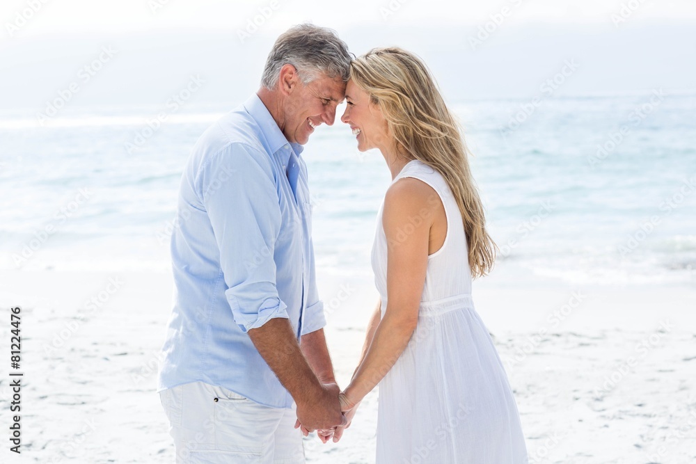 Happy couple holding hands and smiling at each other Happy couple holding hands and smiling at each other