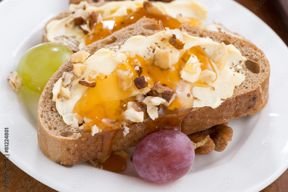 bread with butter, honey, nuts and grapes