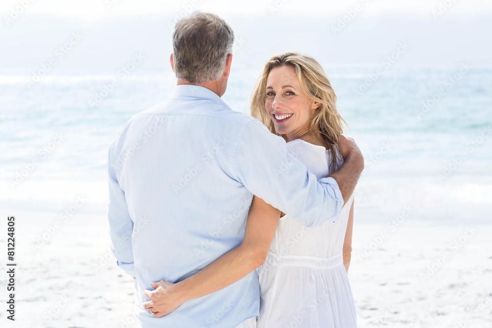 Happy couple standing by the sea arms around Happy couple standing by the sea arms around