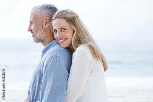 Happy couple hugging each other and looking at the sea