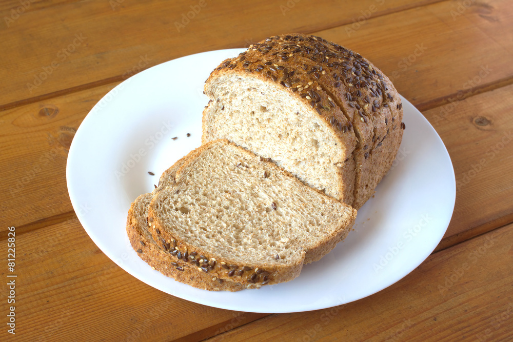 Sliced wholegrain bread lies on white plate closeup