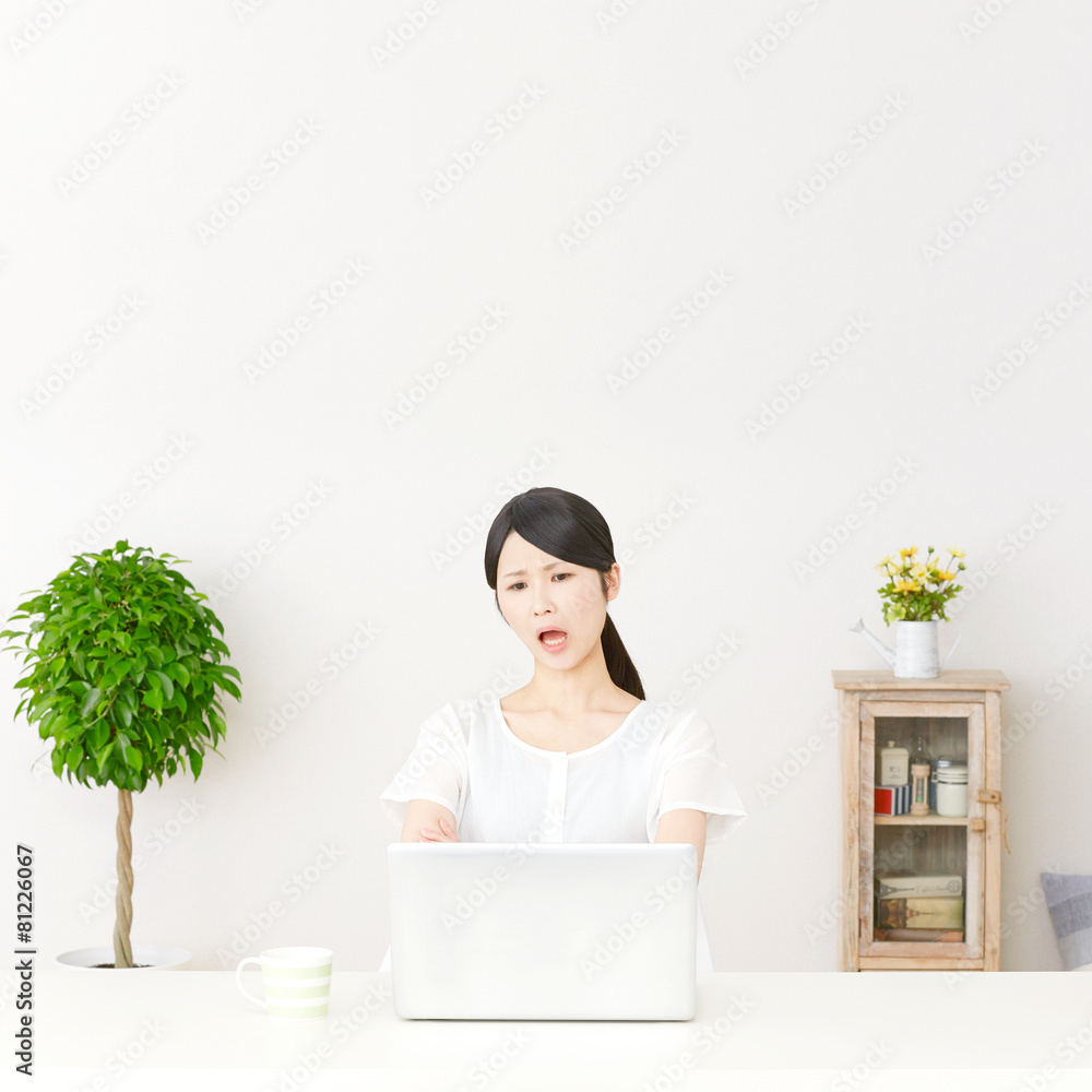 パソコンの前に座って怒る女性 パソコンの前に座って怒る女性