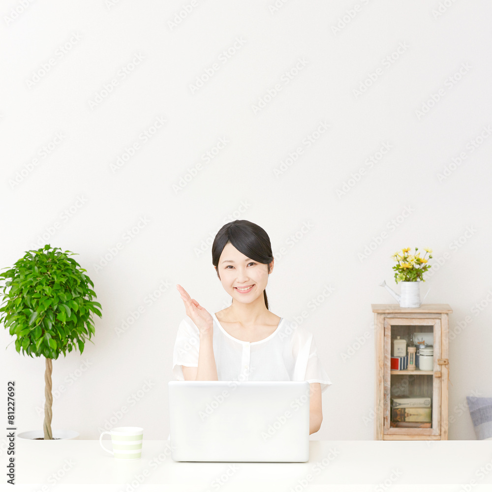 パソコンの前に座って案内する女性 パソコンの前に座って案内する女性
