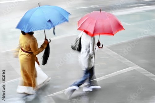 business people walking in the street on a rainy day motion blur