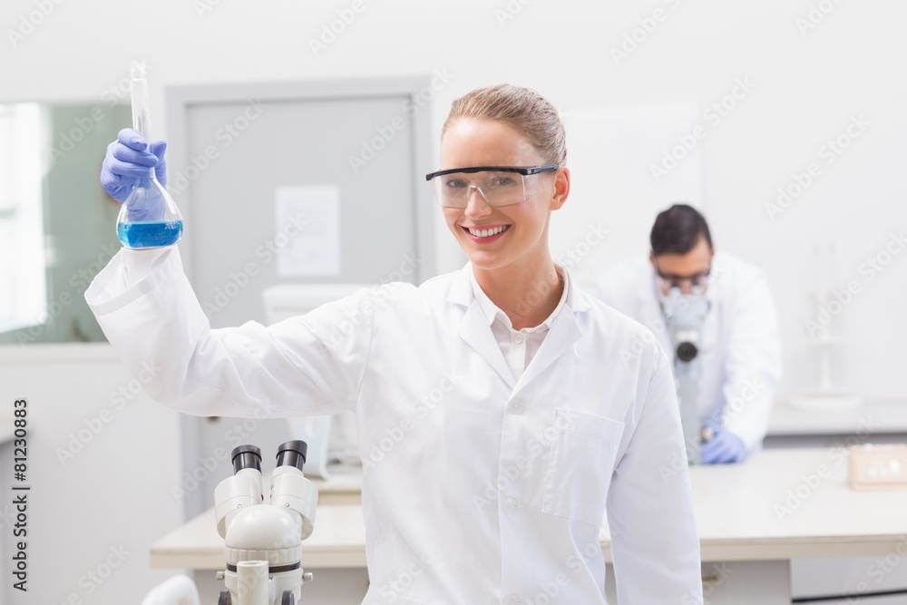 Scientist examining blue precipitate in baker