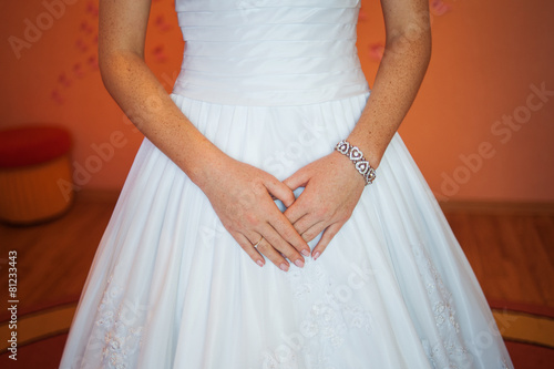 Hands of a bride in her wedding dress