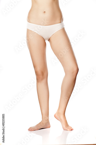 beautiful female barefoot legs on white. bodycare concept