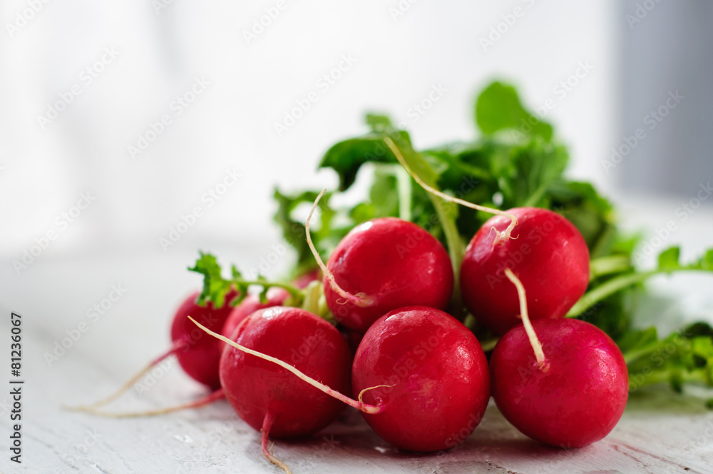 Bunch of fresh radishes on white board Bunch of fresh radishes on white board