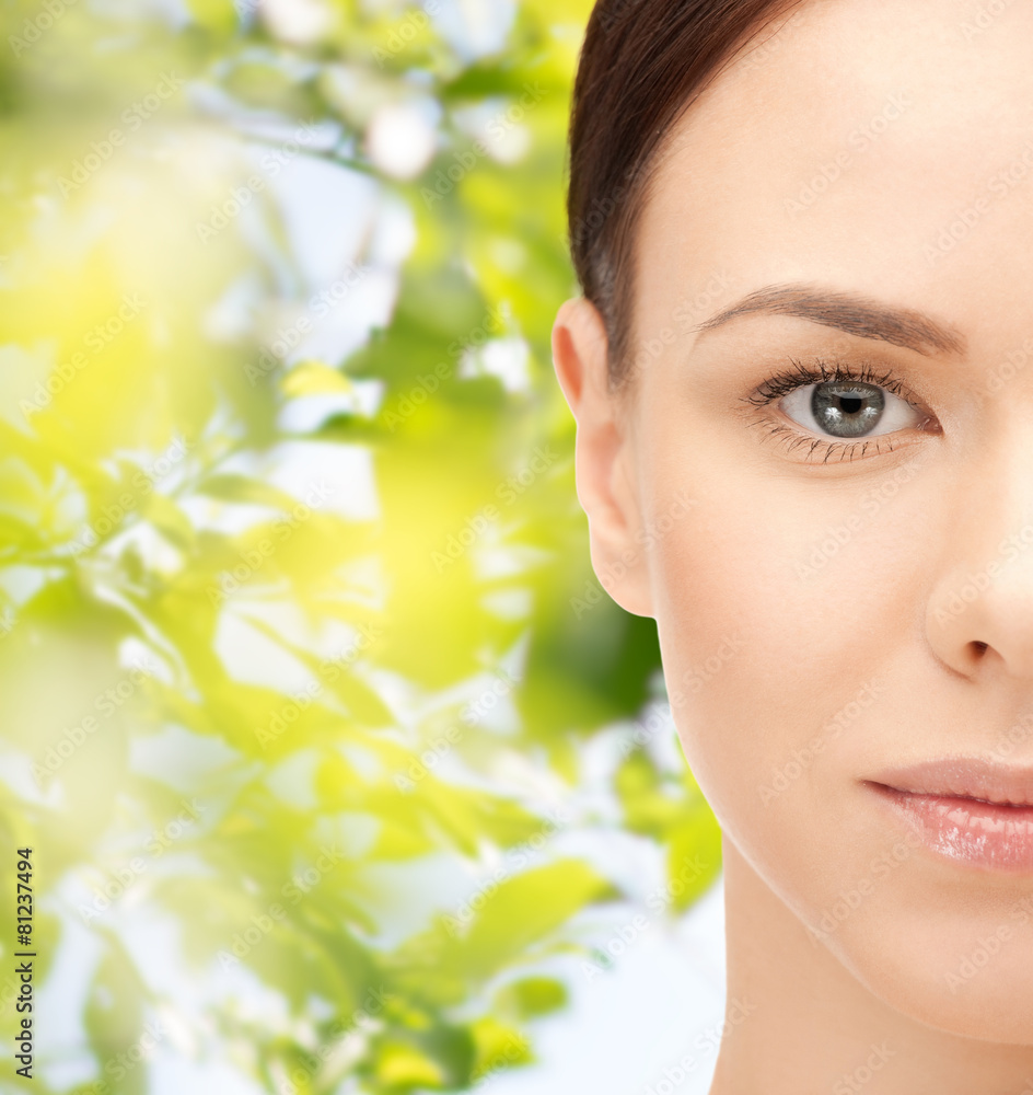 young woman face over green leaves background young woman face over green leaves background