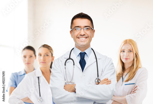 smiling male doctor in white coat at hospital