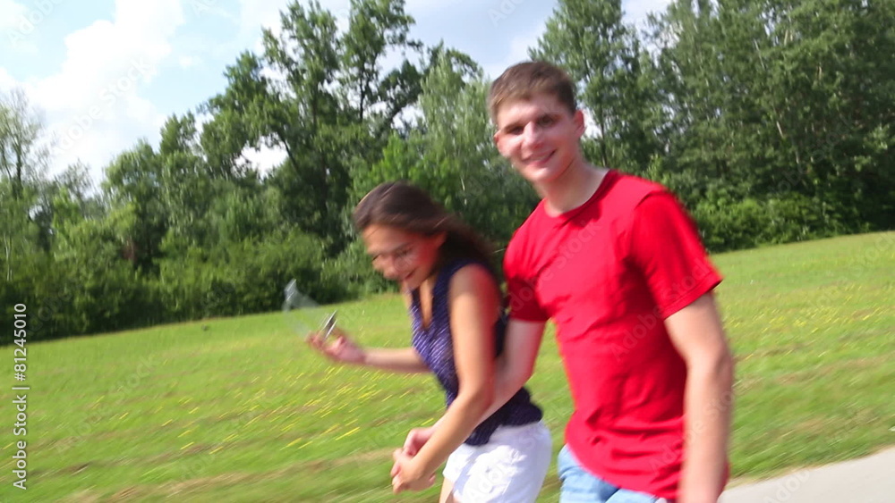 Young woman and man rollerblading on a beautiful sunny summer day in park, holding hands Young woman and man rollerblading on a beautiful sunny summer day in park, holding hands