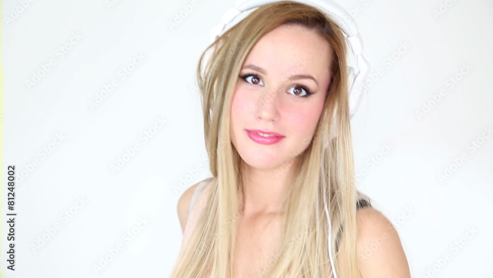 Close up of beautiful young blond woman dancing with white headphones Close up of beautiful young blond woman dancing with white headphones