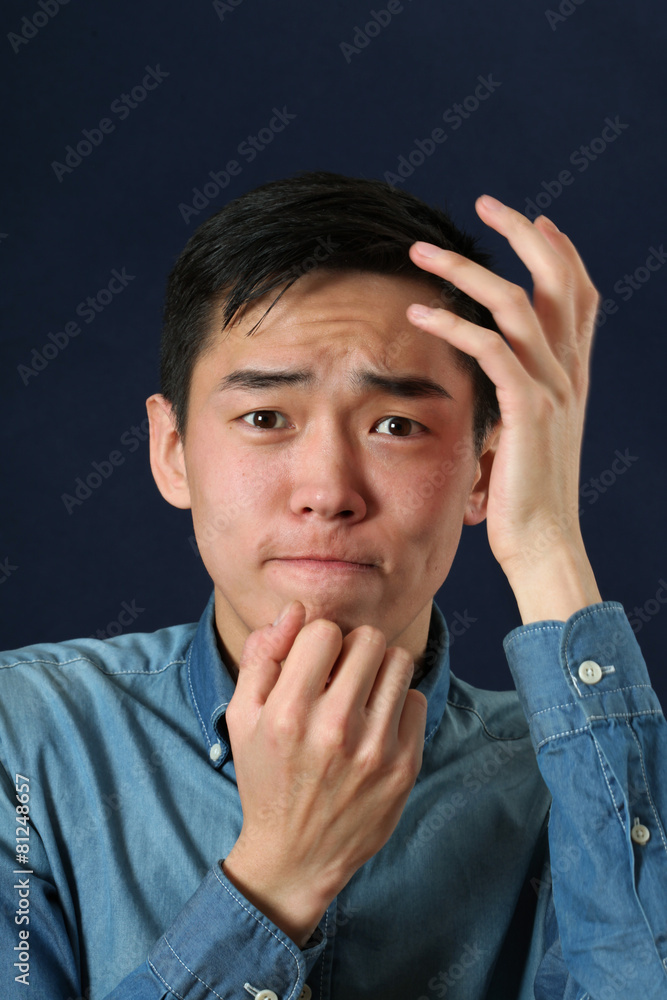 Disappointed young Asian man looking at camera Disappointed young Asian man looking at camera