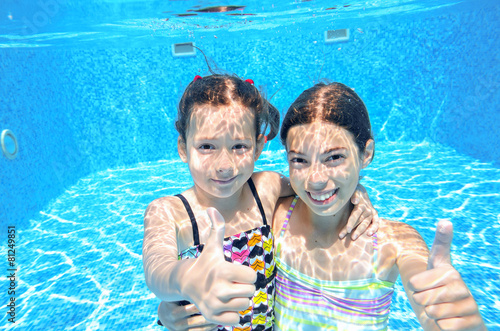 Children swim in pool underwater, girls swimming, kids sport