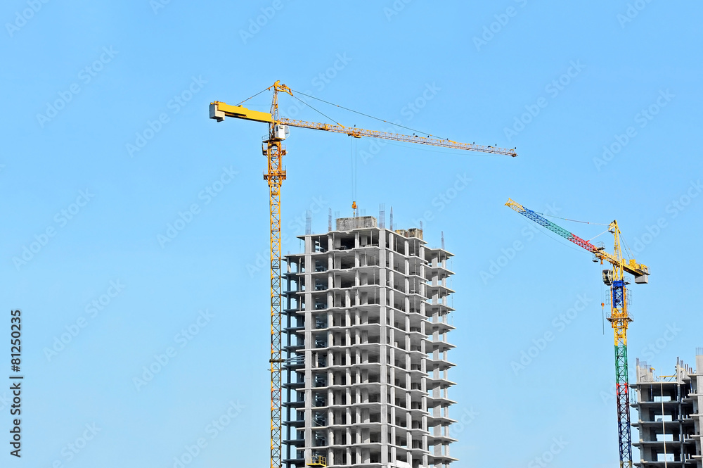 Crane and building construction site against blue sky Crane and building construction site against blue sky