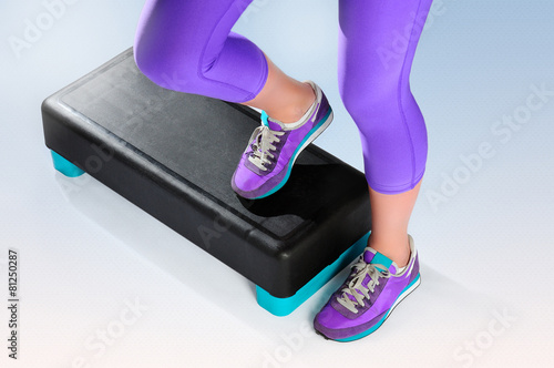 Female feet do exercise on fitness aerobic stepper.