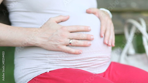 Wallpaper Mural close up woman sitting on bench touching pregnant belly Torontodigital.ca