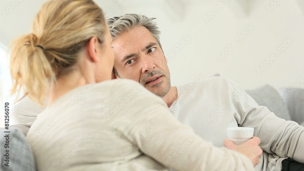 Mature couple relaxing in sofa and having a talk Mature couple relaxing in sofa and having a talk