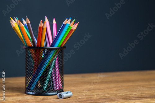 Bunch of color pencils in a stand with sharpener photo