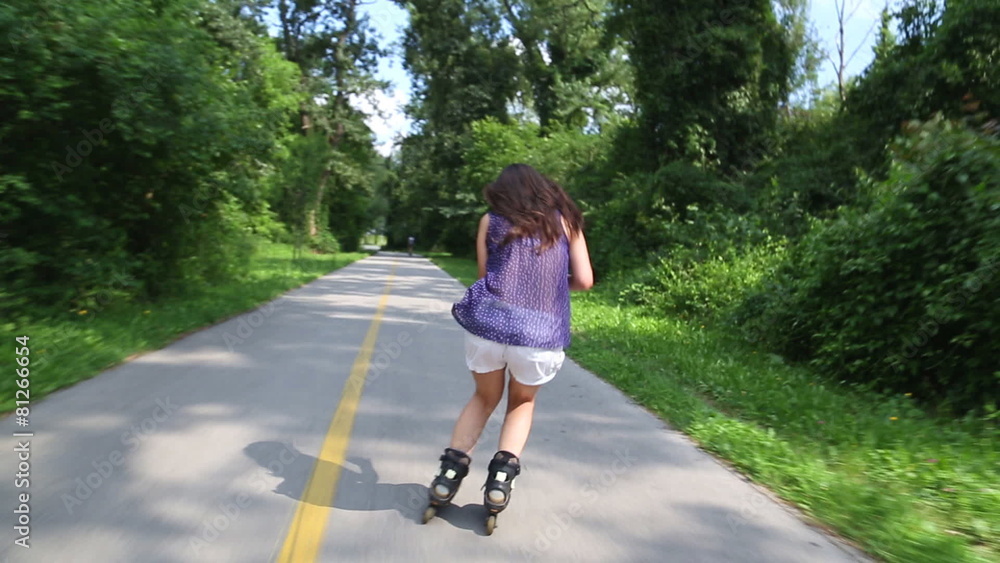 Young attractive woman rollerblading in park on a beautiful sunny day, doing slalom Young attractive woman rollerblading in park on a beautiful sunny day, doing slalom