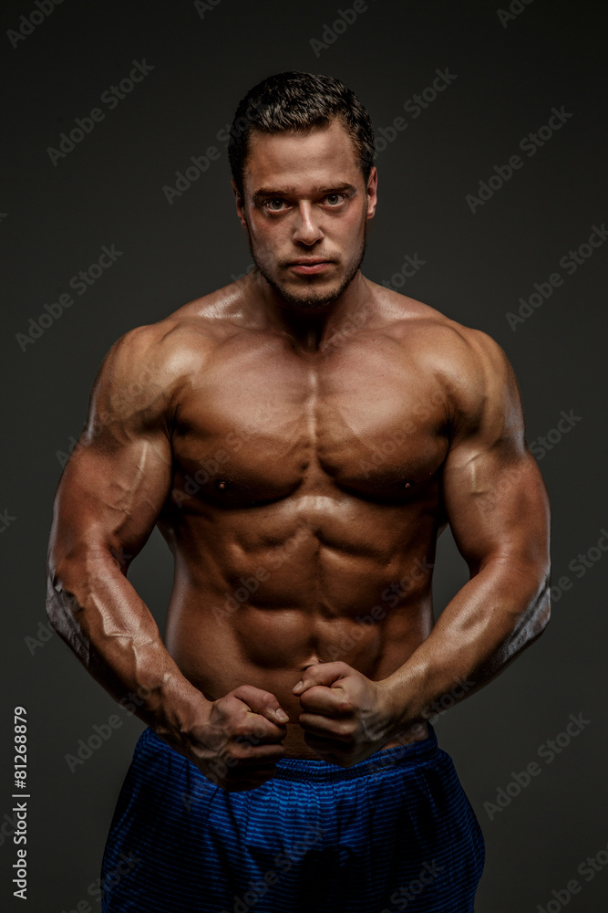 Awesome muscular guy posing in studio.