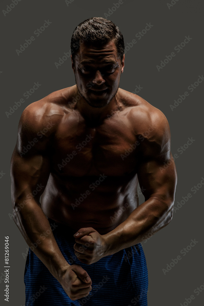 Awesome muscular guy posing in studio.