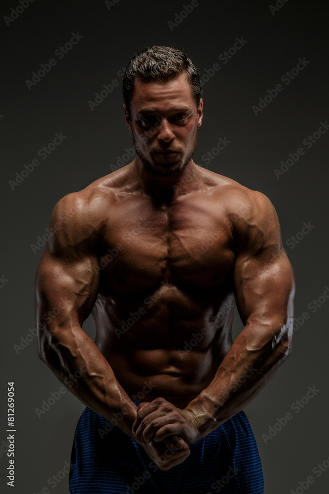 Awesome muscular guy posing in studio.