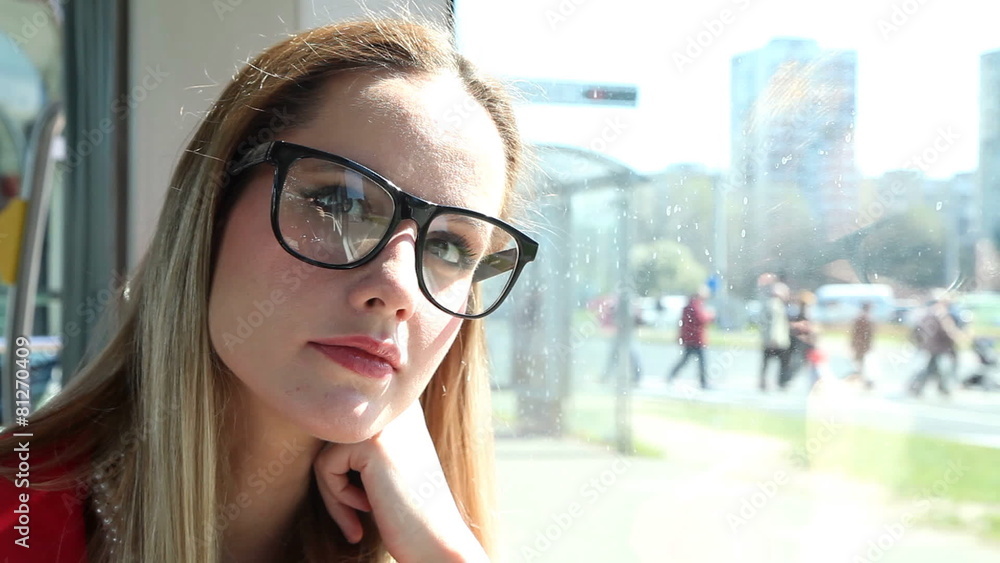 Young blond woman sitting in tram, talking and smiling Young blond woman sitting in tram, talking and smiling