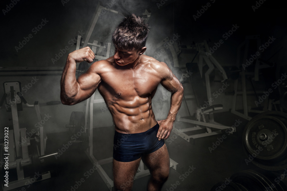 Bodybuilder man showing his biceps in gym